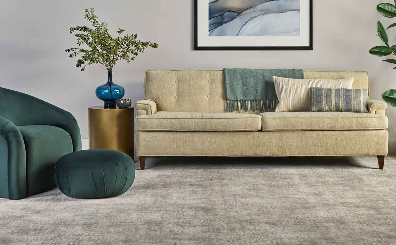 stylish living room with soft grey carpets and earth toned furniture